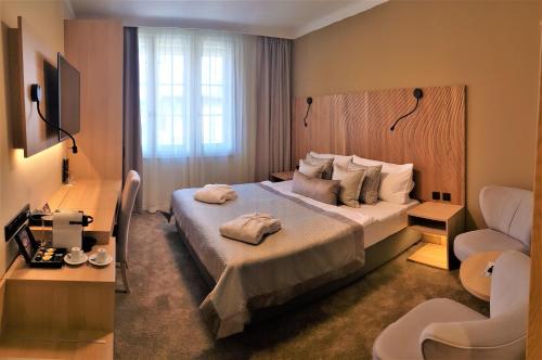 Hotel Clement في براغ: غرفه فندقيه بسرير وكرسي