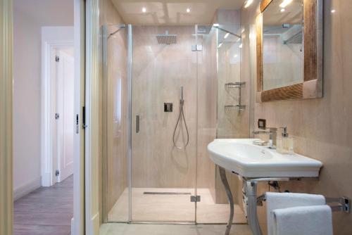 y baño con ducha y lavamanos. en Suite Milano Duomo, en Milán