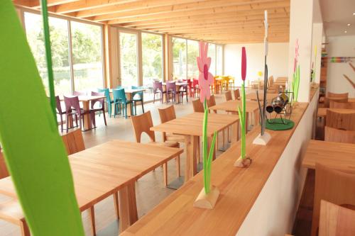 a restaurant with wooden tables and chairs and windows at Hotel Sunnegässle in Rust