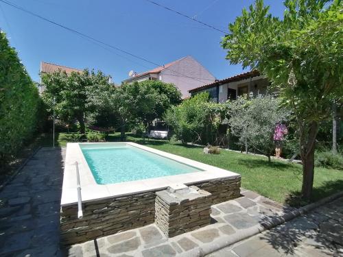 una piscina en el patio trasero de una casa en O Ze Ja Dormiu Aqui, en Celeirós