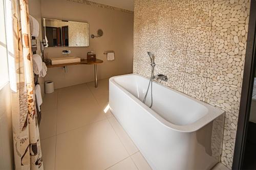 a bathroom with a white tub and a sink at Château de la Falque, The Originals Relais in Saint-Geniez-dʼOlt