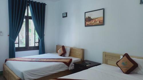 a bedroom with two beds and a window at Muine Pacific Resort in Mui Ne