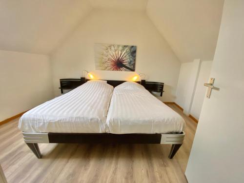 a bedroom with a large white bed with lights on it at Zandvoort Central Apartment in Zandvoort