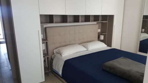 a bedroom with a large bed with a blue blanket at Residenza sul Mare in Civitanova Marche