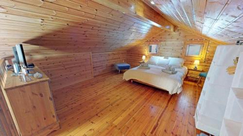 1 dormitorio con 1 cama en una cabaña de madera en Méribel Chalet Merveilleux en Les Allues