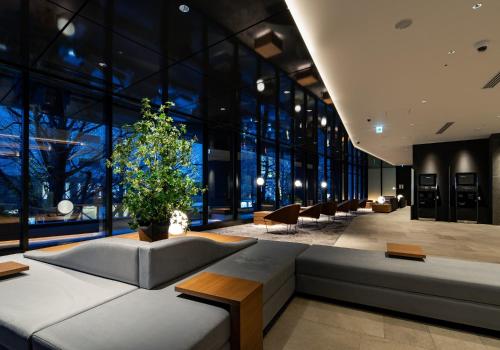 a lobby with a couch and chairs in a building at Daiwa Roynet Hotel Sendai Ichibancho PREMIER in Sendai