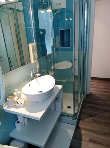 a bathroom with a sink and a glass shower at Hotel Orchidea in Bardolino