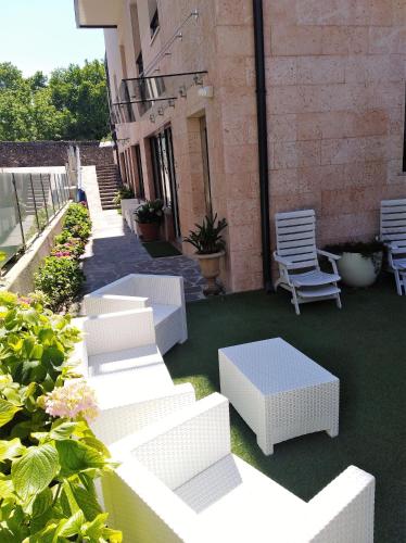 a group of white chairs and tables on a patio at Hotel Orchidea in Bardolino