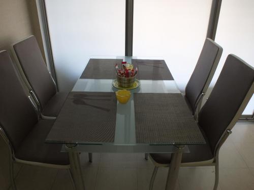 a dining room table with chairs and a bowl ofcolored pens at Apartment Temple in Podgorica