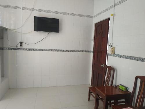 um quarto com uma mesa e uma televisão na parede em Nhà Nghỉ Xuân Biển em Cao Lãnh