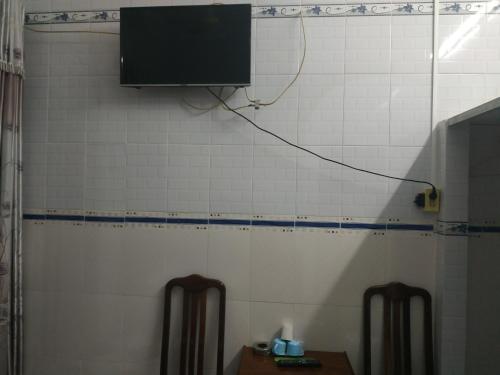 uma televisão numa parede numa casa de banho com uma mesa em Nhà Nghỉ Xuân Biển em Cao Lãnh