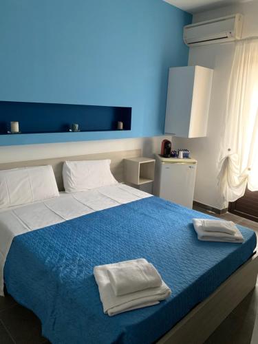 ein Schlafzimmer mit einem Bett mit zwei Handtüchern darauf in der Unterkunft San Giorgio Rooms in Caltagirone