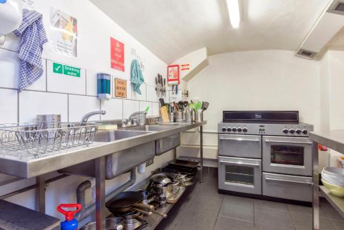 una cucina con lavandino e piano cottura di Astor Kensington Hostel a Londra