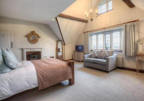 a bedroom with a bed and a couch and a chair at Weston Hall in Stafford