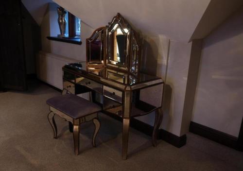 a dressing table with a chair and a mirror at Weston Hall in Stafford