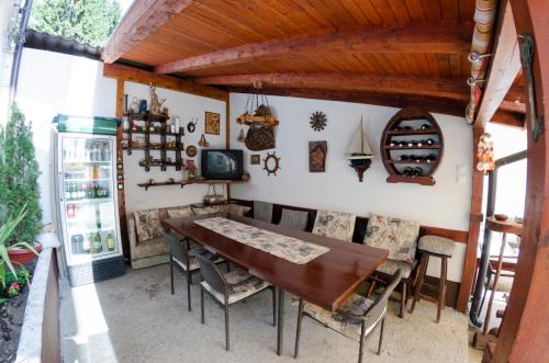 uma sala de jantar com uma mesa de madeira e cadeiras em Guest House Time Out em Sarajevo