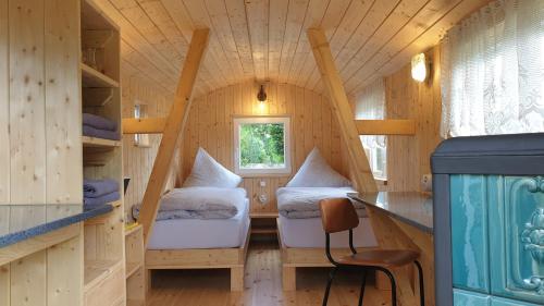 ein Zimmer mit 2 Betten in einem winzigen Haus in der Unterkunft Heinrich's Pension & Ferienwohnungen in Walternienburg