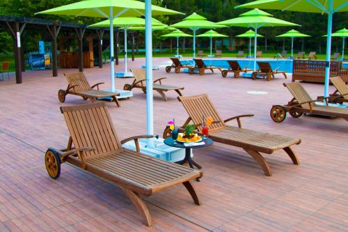 a group of chairs and tables with green umbrellas at RIVER INN RESORT AND SPA in Nabran