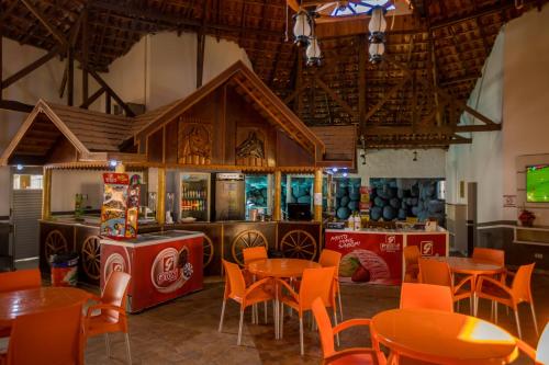 - un restaurant avec des tables et des chaises dans une salle dans l'établissement Ody Park Resort Hotel, à Iguaraçu