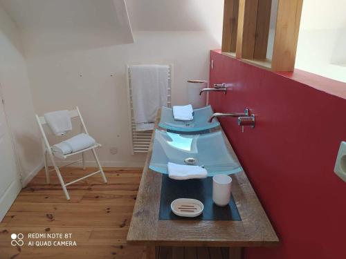 a kitchen with a blue sink and a chair at La petite Hautière Maison 2 personnes Plouer sur Rance avec piscine in Plouër-sur-Rance