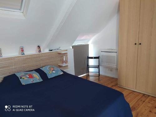a bedroom with a bed with a blue blanket at La petite Hautière Maison 2 personnes Plouer sur Rance avec piscine in Plouër-sur-Rance