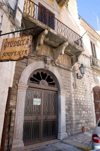 a building with a large door with a sign above it at White House in Trani