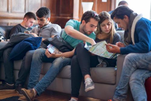 a group of people sitting on a couch looking at a map at Astor Hyde Park Hostel in London