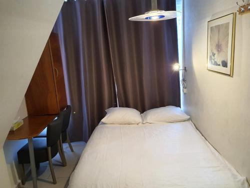 a bed in a room with a table and a window at Hotel Schroder in Amsterdam
