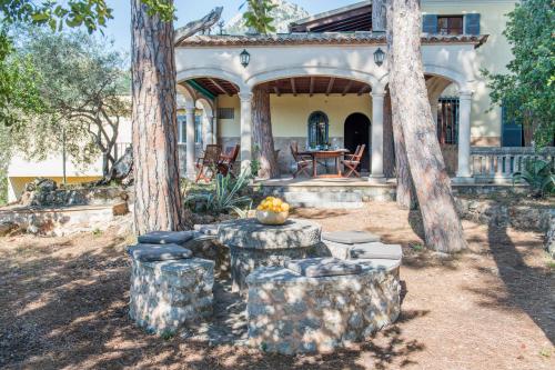 a house with two trees and a table in the yard at Raco de Soller in Sóller