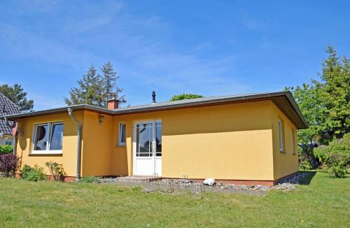 une maison jaune avec un garage dans l'établissement Ferienhaus Sabine mit Kamin und So, à Baabe