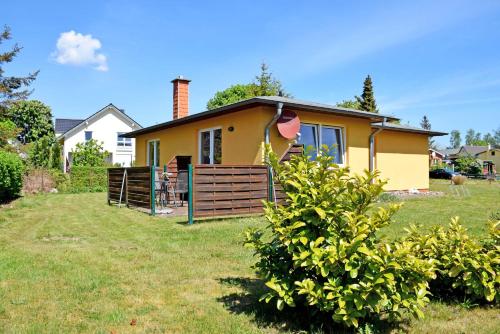 une petite maison jaune dans une cour dans l'établissement Ferienhaus Sabine mit Kamin und So, à Baabe