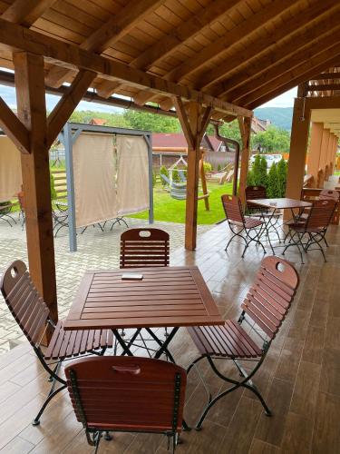 a picnic table and chairs under a wooden pergola at Lex Studio in Praid