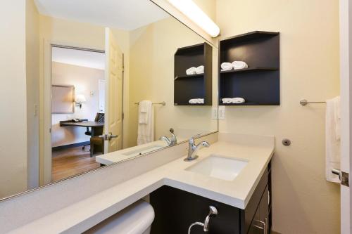 a bathroom with a sink and a mirror at Candlewood Suites Rocky Mount, an IHG Hotel in Rocky Mount