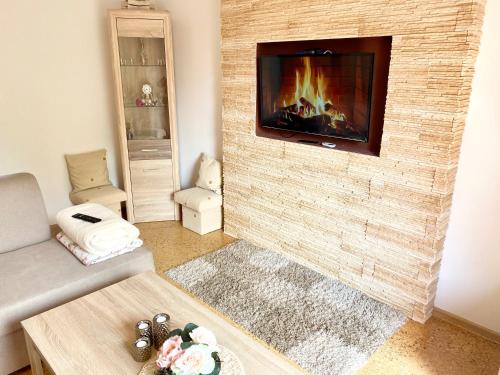 a living room with a fireplace with a tv on a brick wall at Vila EVIO Třeboň in Třeboň