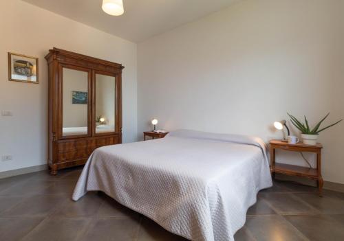 a bedroom with a white bed and a mirror at Mamma Ciccia Holiday Home - Confalonieri in Mandello del Lario