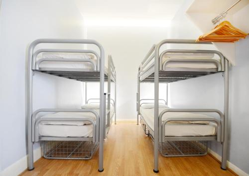 two metal bunk beds in a room with wooden floors at Astor Hyde Park Hostel in London