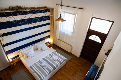 a bedroom with a bed with a blue and white striped wall at Charlietown in Satu Mare