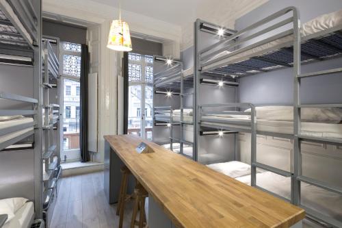ロンドンにあるアスター ハイド パーク ホステルの二段ベッドと木製テーブルが備わる客室です。