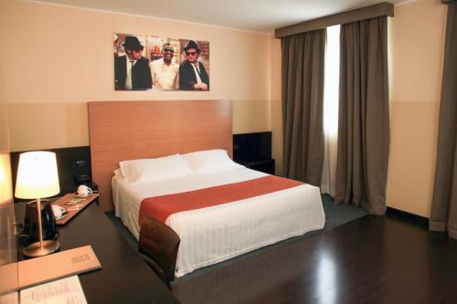 Habitación de hotel con cama grande y ventana en Hotel Studios, en Cologno Monzese