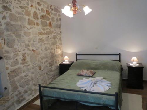 a bedroom with a bed with two lamps and a stone wall at Villa zita in Poreč