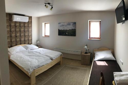 A bed or beds in a room at Berger Pince és vendégház
