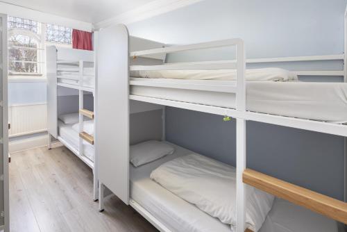 a room with white bunk beds in it at Astor Hyde Park Hostel in London