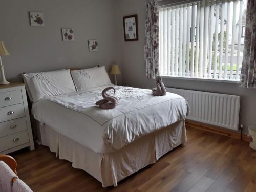 a bedroom with a bed with two wooden snakes on it at Tranquility Portstewart in Portstewart