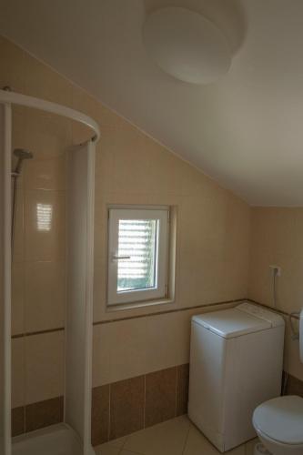 a bathroom with a toilet and a window at Beach Apartments Marijana in Vodice