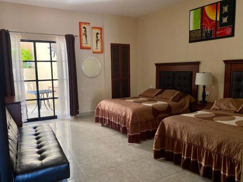ein Hotelzimmer mit 2 Betten und einem Fenster in der Unterkunft Hotel Villa Bernal in Bernal