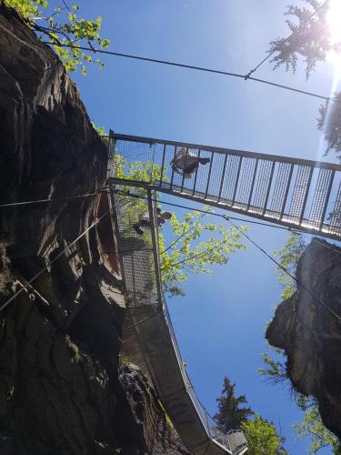a bridge over a mountain with a person on it at Hotel Beau-Séjour in Leukerbad