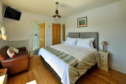 a bedroom with a large bed and a chair at Beacon House B&B Brixham in Brixham