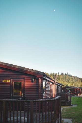 a log cabin with a fence in front of it at Lodge at Loch Lomond in Glasgow