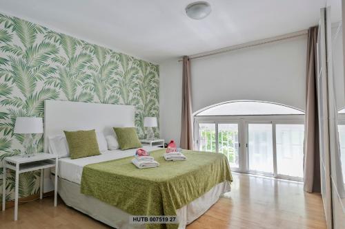 een slaapkamer met een bed met groen en wit behang bij Alcam Office up in Barcelona