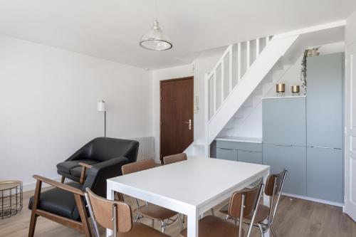 un salon avec une table et des chaises blanches dans l'établissement Élégant appartement à quelques pas de la plage, à Pornichet